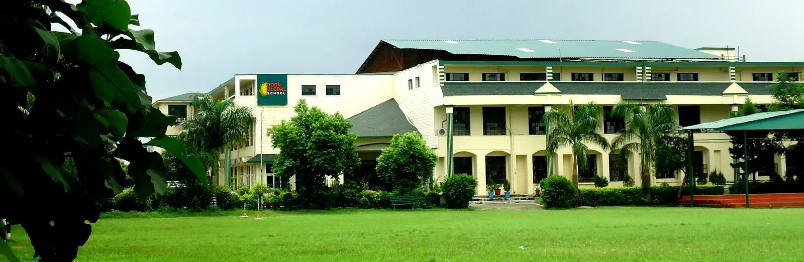 The Doon Global School campus in Dehradun, framed by green leaves