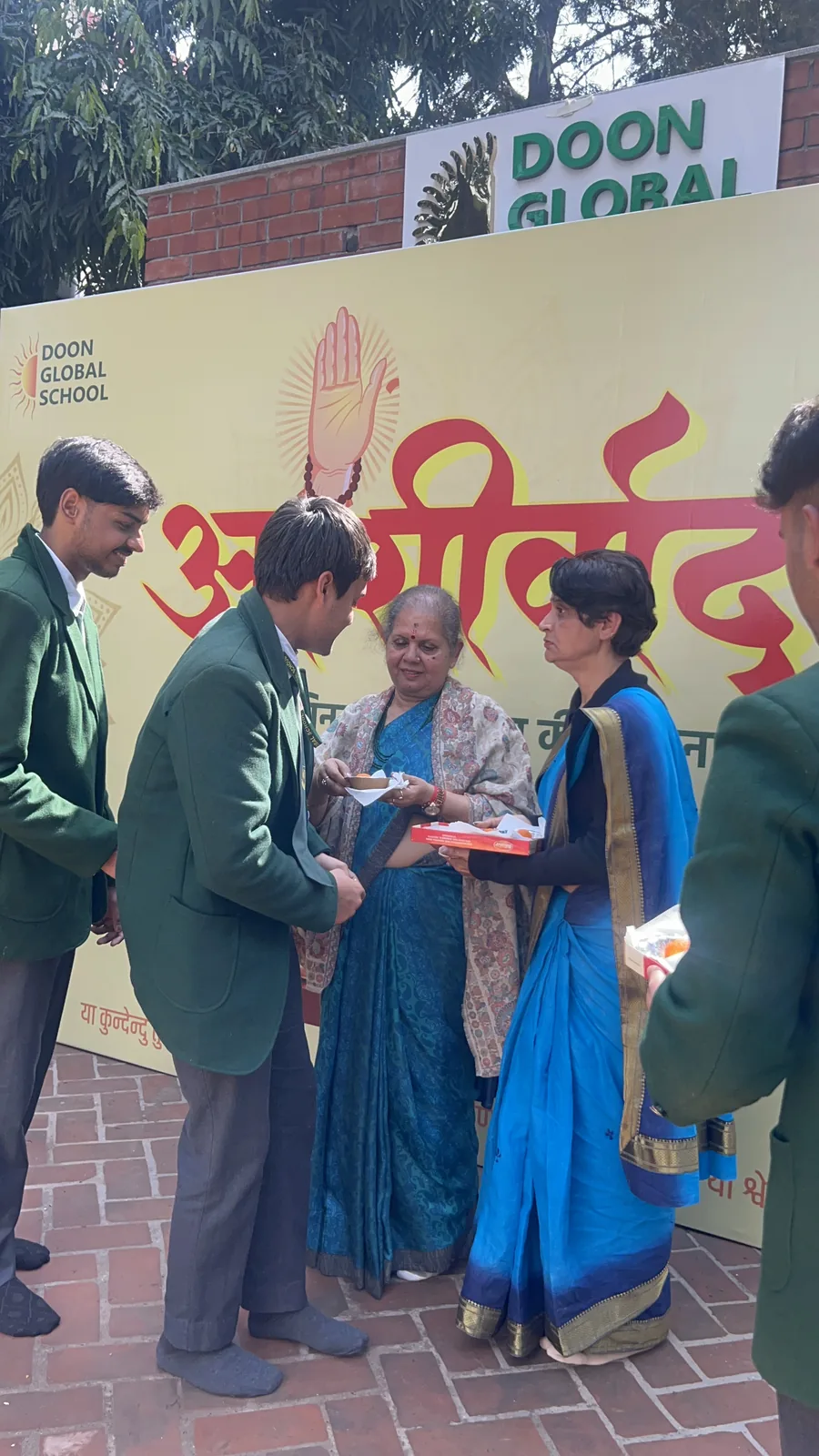 A student receiving prasad and blessings from a teacher at the Ashirwad ceremony