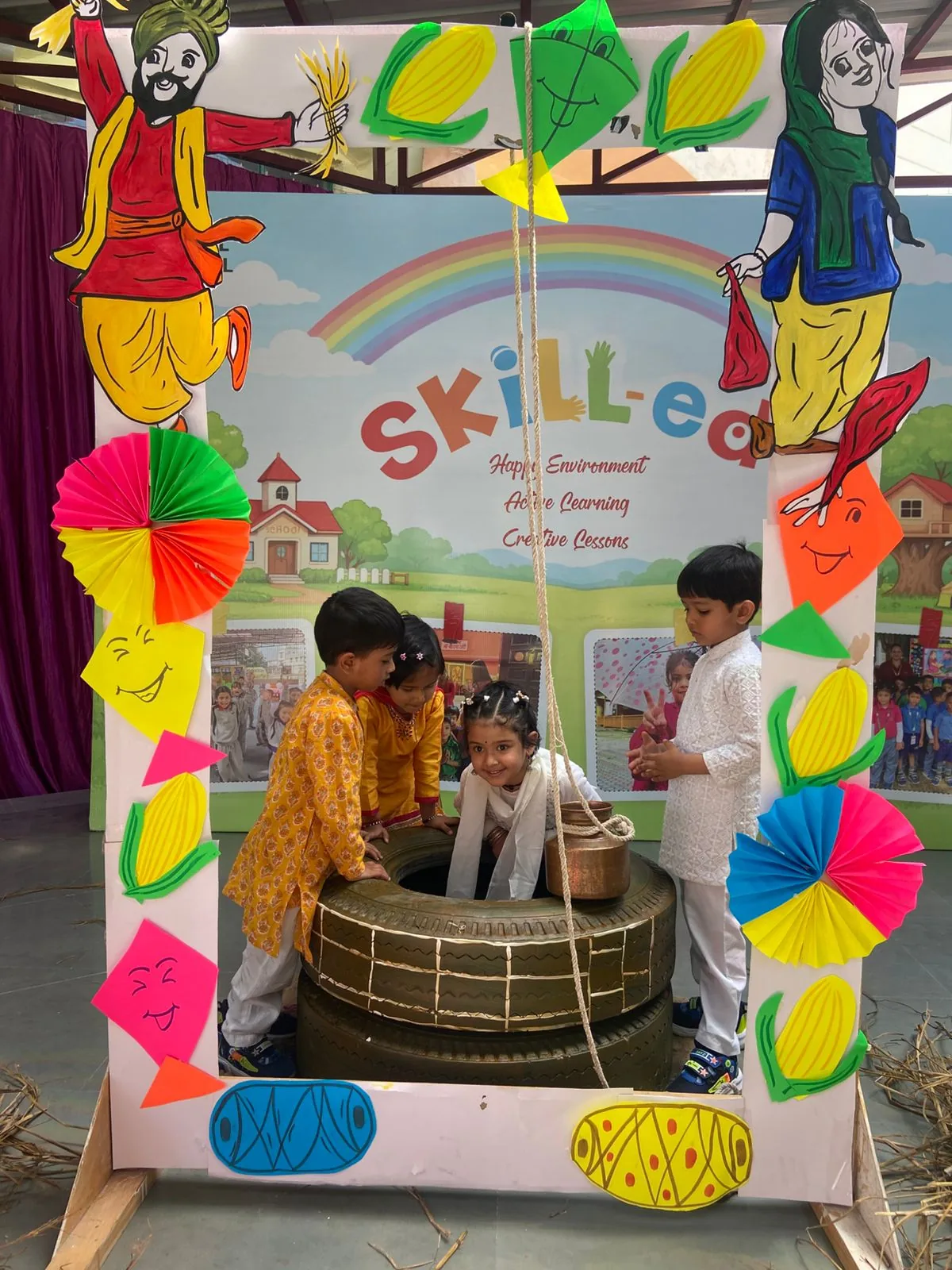 Junior students in traditional dress at a decorated Baisakhi photo frame