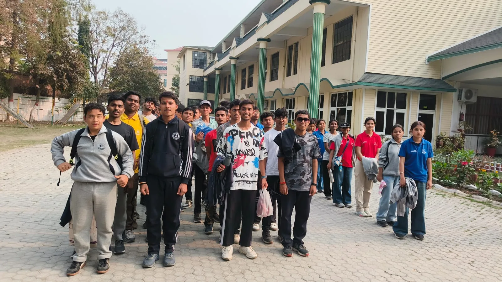 Students in casual clothes walking together outside a building on an educational trip