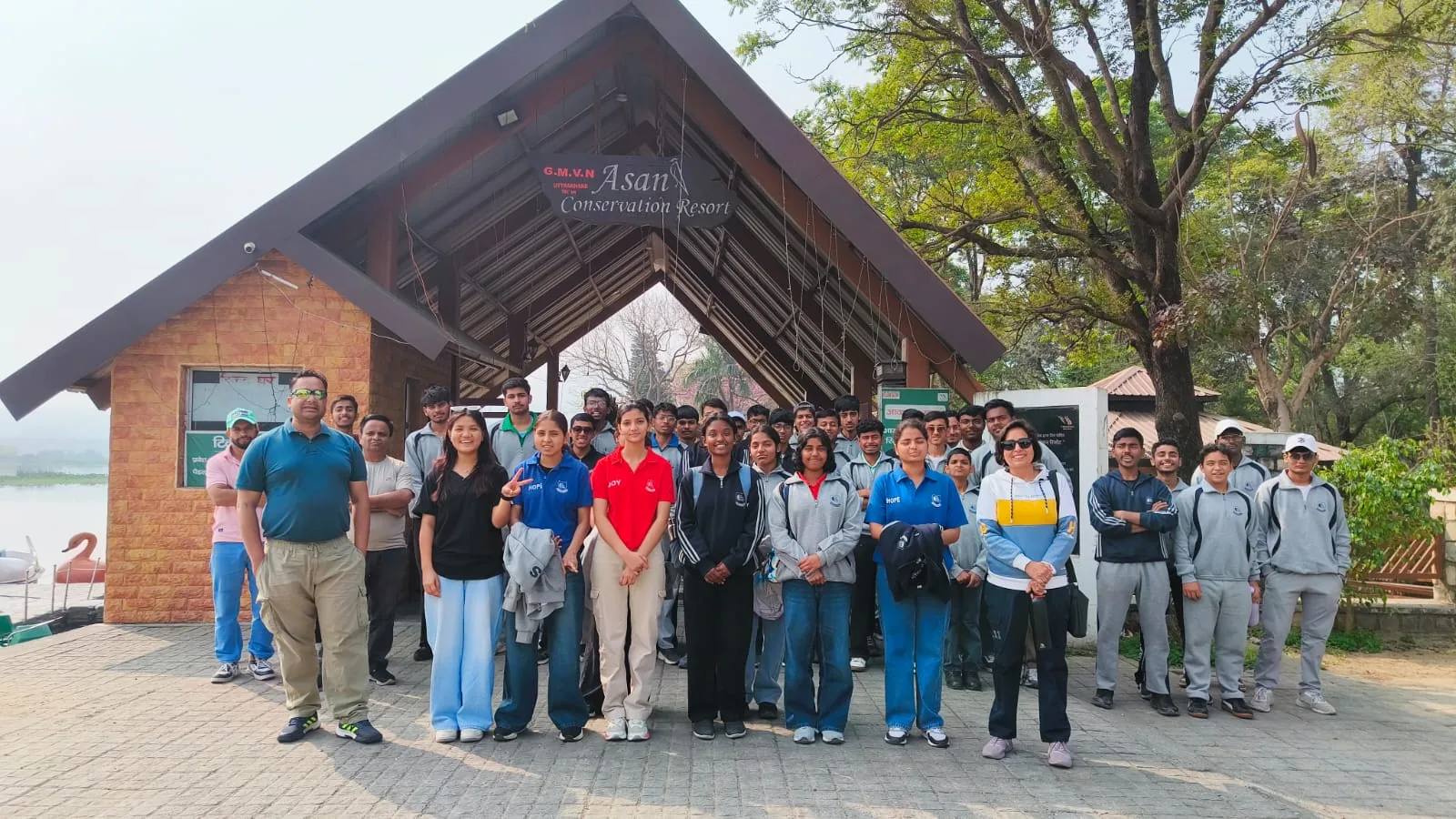 Students and teachers gathered at the entrance of a lakeside centre on an educational trip