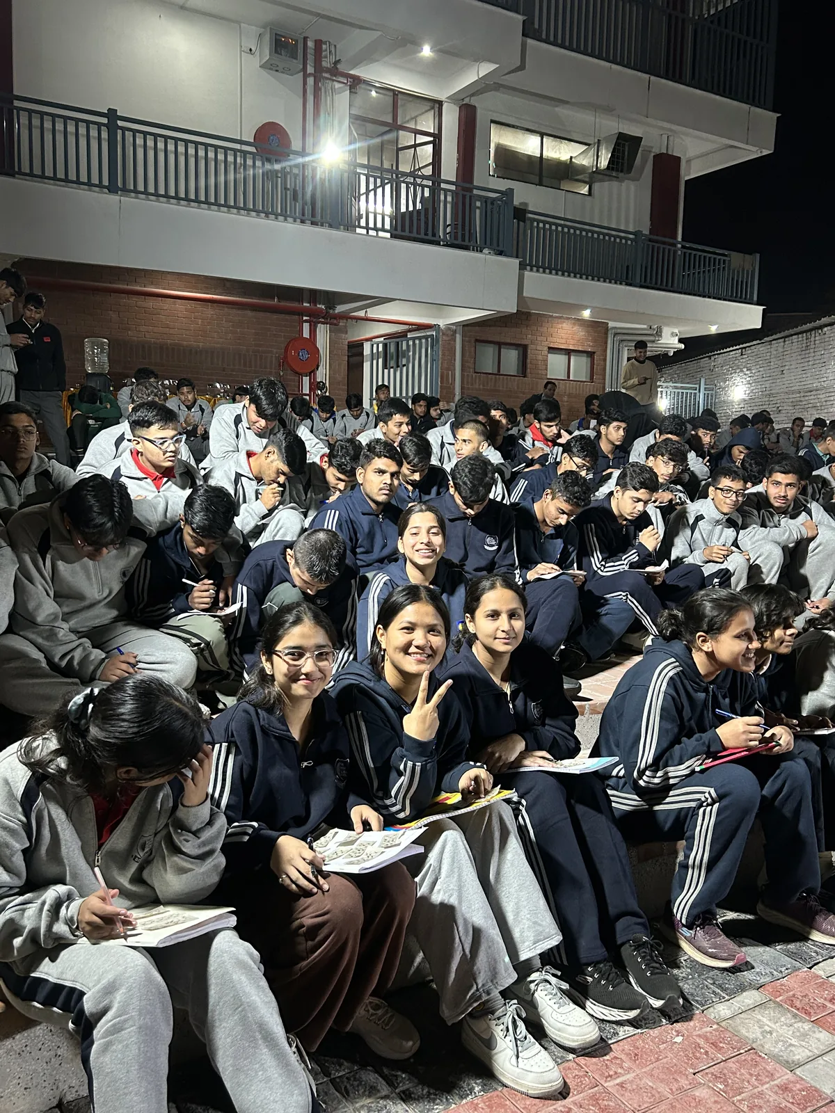Students seated together in the courtyard during the evening gathering