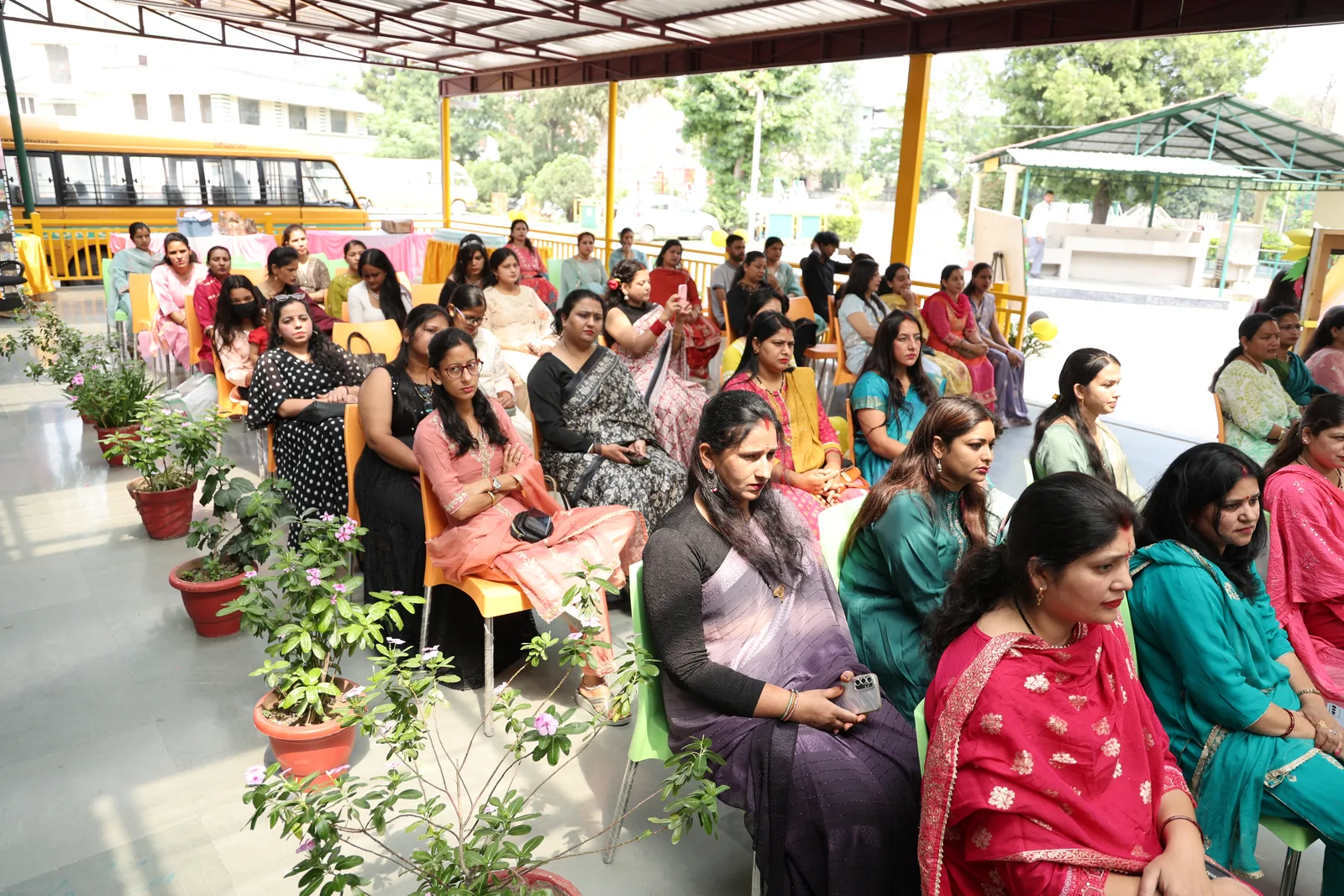 Parents seated under the covered assembly area watching the programme